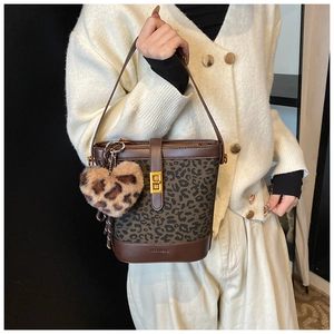 Detail of leopard print bucket bag with brown leather trim and heart plush charm