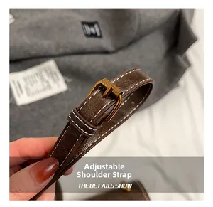 Details des verstellbaren dunkelbraunen Lederriemens mit goldener Schnalle und Naht