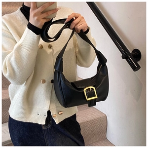 Dettaglio della borsa hobo in pelle nera martellata con fibbia dorata decorativa