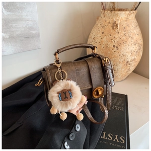 Nahaufnahme der braunen Vintage-Leder-Boston-Bag mit Goldverschluss und Lamm-Anhänger
