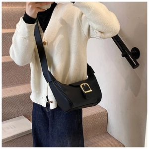 Modella indossa una borsa a tracolla nera a mezzaluna con fibbia dorata sulla scala