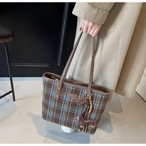 Classic plaid tote bag detail with brown leather straps and cute sausage dog pendant