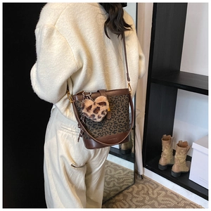 Close-up of vintage leopard print bucket bag with heart-shaped plush charm detail