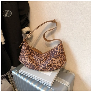 Détail de la bandoulière réglable et du motif léopard sur ce sac à bandoulière en croissant