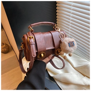 Details der braunen Vintage-Leder-Boston-Tasche mit goldener Schnalle und Lamm-Anhänger