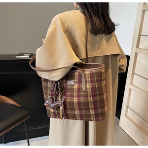 Detail of checkered tote bag in brown wool with leather straps and dachshund charm