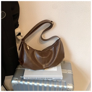 Détail du sac hobo en cuir texturé marron foncé avec fermeture éclair dorée