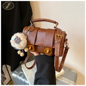 Detailansicht der braunen Boston-Tasche mit Ledertextur und goldenem Verschluss