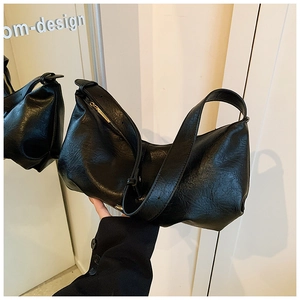 Gros plan sur le sac en cuir PU noir avec plis souples et fermeture éclair dorée