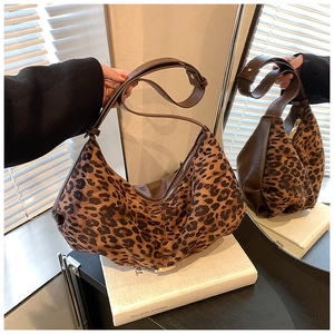 Détail du sac hobo léopard avec bordures en cuir marron et finitions zippées métalliques