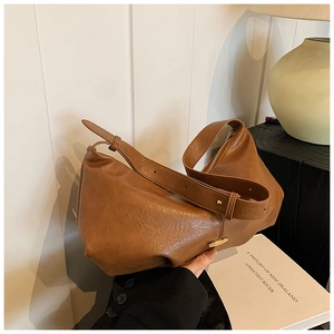 Détail du sac hobo en cuir caramel avec texture grainée vintage et large bandoulière