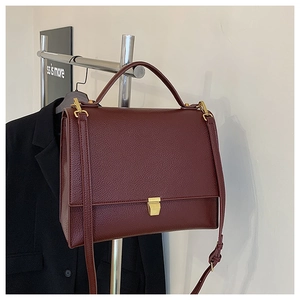 Detail of vintage burgundy small square bag featuring lychee grain leather and gold buckle