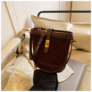 Detail of dark brown suede bucket bag with gold square twist lock and smooth leather trim