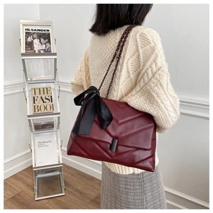 Détail du sac cabas bordeaux matelassé avec texture en V et nœud en satin noir