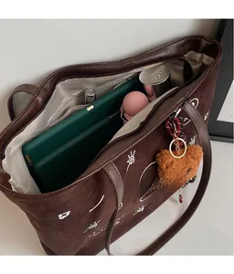Detailed view of large dark brown suede tote bag showing spacious storage capacity