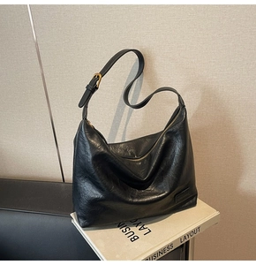Dettaglio della borsa hobo nera capiente in pelle morbida con tracolla regolabile e fibbia oro