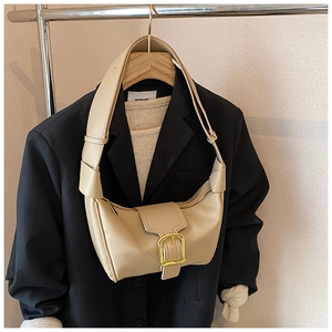 Dettaglio della borsa a mezzaluna beige in pelle martellata con fibbia quadrata d'oro