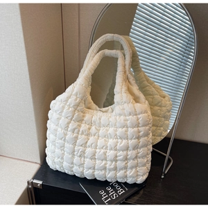 Detailed view of the white quilted puffy tote bag with soft bubble texture and handle