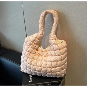Detail of light pink quilted tote bag showing soft puffy texture and grid stitching