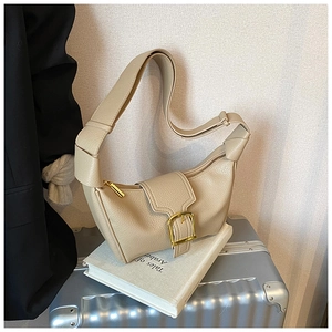 Dettaglio borsa a mezzaluna beige in pelle martellata con tracolla annodata e fibbia