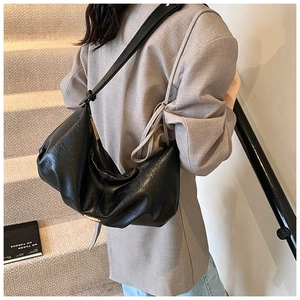 Vue détaillée du sac hobo en cuir noir avec fermeture éclair dorée et bandoulière
