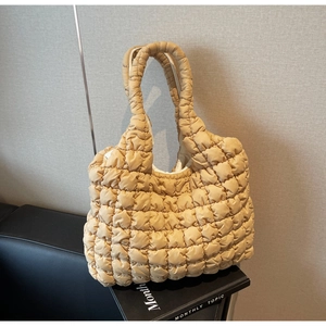 Close-up of ginger yellow quilted bubble tote bag with glossy polyester texture details