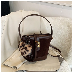 Detail of dark brown vintage bucket bag with leopard heart charm and gold hardware