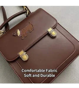 Detail of vintage brown leather backpack with dachshund patch and gold metal buckles