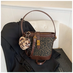 Detailed shot of retro leopard print bucket bag with metal lock and plush heart charm