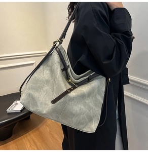 Detail der Vintage-Jeans-Tasche mit braunen Lederriemen und gealterter Wolkenstruktur