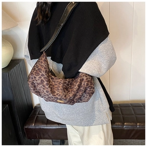Détail du sac hobo léopard avec bandoulière en cuir noir et accents métalliques dorés