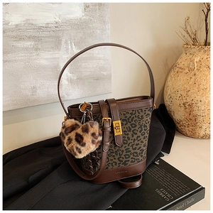 Detail of leopard print bucket bag with gold lock, leather trim and heart charm