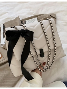 Sac à bandoulière beige matelassé en V avec nœud noir et bandoulière chaîne