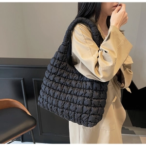 Detailed texture of black quilted tote bag showing cloud-like puffed nylon fabric