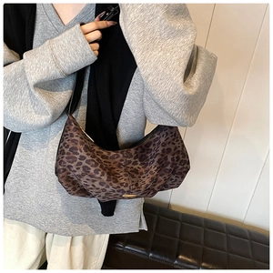 Détail du sac hobo à imprimé léopard porté par un mannequin en pull gris chic