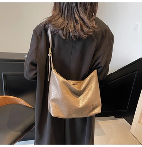 Dettaglio della borsa hobo marrone metallizzato con tracolla regolabile sulla spalla