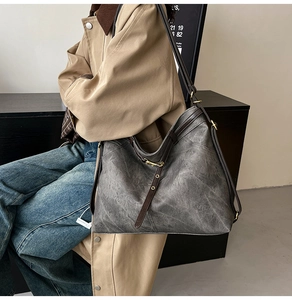 Macro shot of vintage gray tote bag with brown straps and metallic gold buckle details
