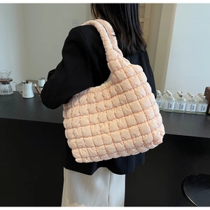 Detail of light pink quilted puffer tote bag showing large capacity and soft texture