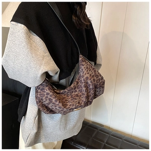 Détail du sac bandoulière à imprimé léopard avec sangle noire et boucle argentée