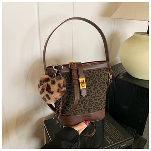 Detail of leopard print bucket bag with gold twist lock and heart plush charm