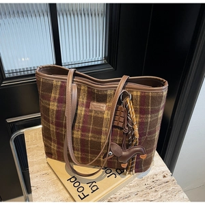 Detail of vintage plaid tote bag with teddy bear leather tag and chocolate dachshund charms