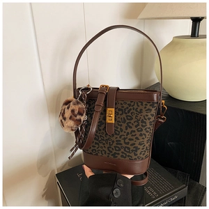 Detail of leopard print bucket bag with gold clasp and plush charm accessory