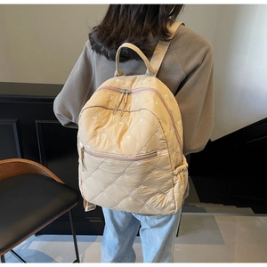 Détail du sac à dos matelassé beige avec broderie nœud et bretelles réglables