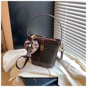 Detail of leopard print bucket bag with leather trim, bronze hardware and heart charm