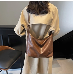 Dettaglio di borsa hobo vintage in pelle marrone con tracolla regolabile e fibbia