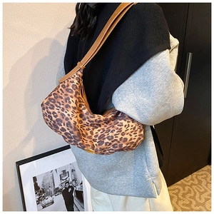 Photo mannequin d'un sac à bandoulière léopard en forme de croissant avec sangle en cuir