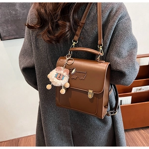 Detail view of vintage brown backpack with dachshund embroidery and lion plush charm