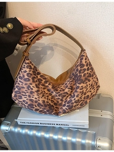 Sac hobo rétro à imprimé léopard avec bandoulière en cuir sur une valise stylée