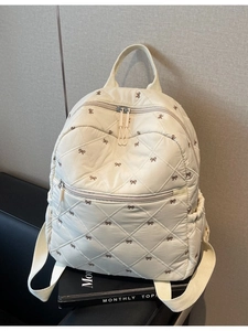 Sac à dos beige matelassé avec des nœuds brodés marron et des poches multiples