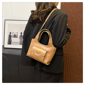 Vue détaillée du sac seau vintage en cuir PU marron avec poche avant sur modèle